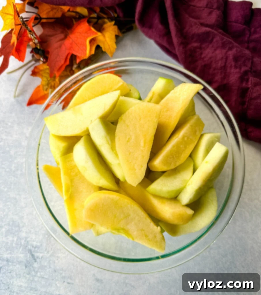 sliced and cored apples in a glass bowl