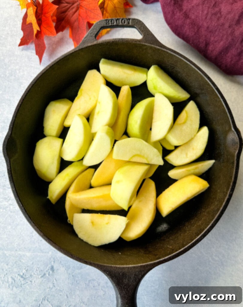 Down-Home Fried Apples 6 Sliced Granny Smith apples arranged in a cast iron skillet, ready for cooking.