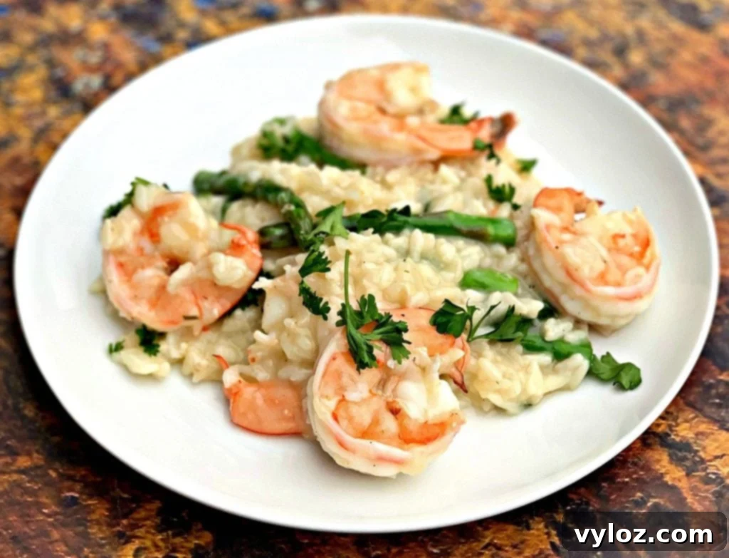 No-Stir Creamy Instant Pot Shrimp Risotto 2 Instant Pot Shrimp Risotto on a white plate, garnished with fresh herbs and lemon wedges.