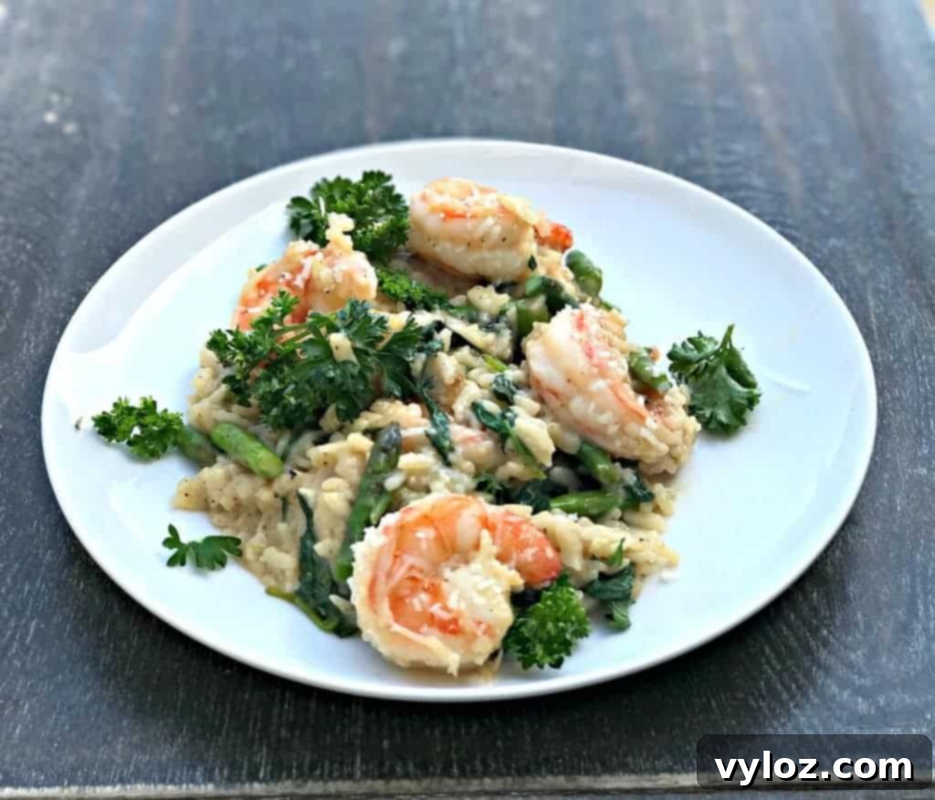 No-Stir Creamy Instant Pot Shrimp Risotto 7 Lemon Shrimp Risotto with Vegetables and Parmesan served on a white plate, garnished with a lemon wedge.