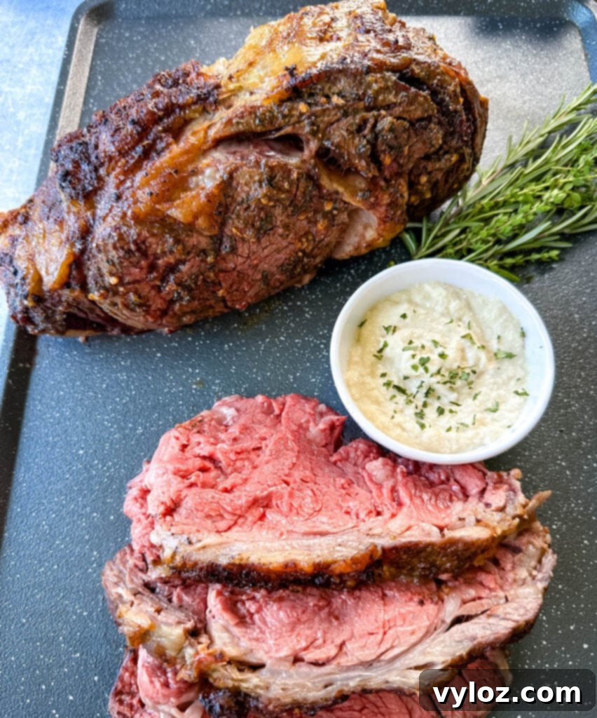 Bone-in or Boneless Garlic Butter Prime Rib 14 garlic herb butter roasted prime rib sliced on a sheet pan with horseradish