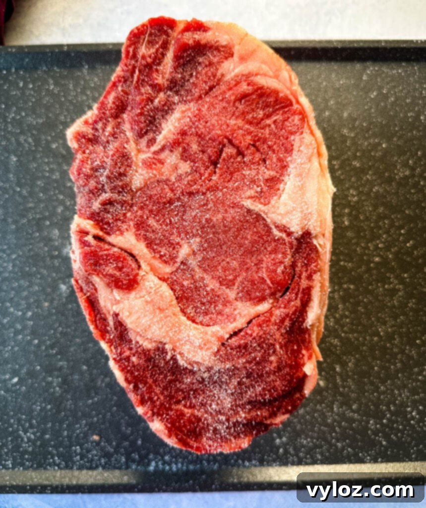 Bone-in or Boneless Garlic Butter Prime Rib 3 raw prime rib roast on a sheet pan with Kosher salt