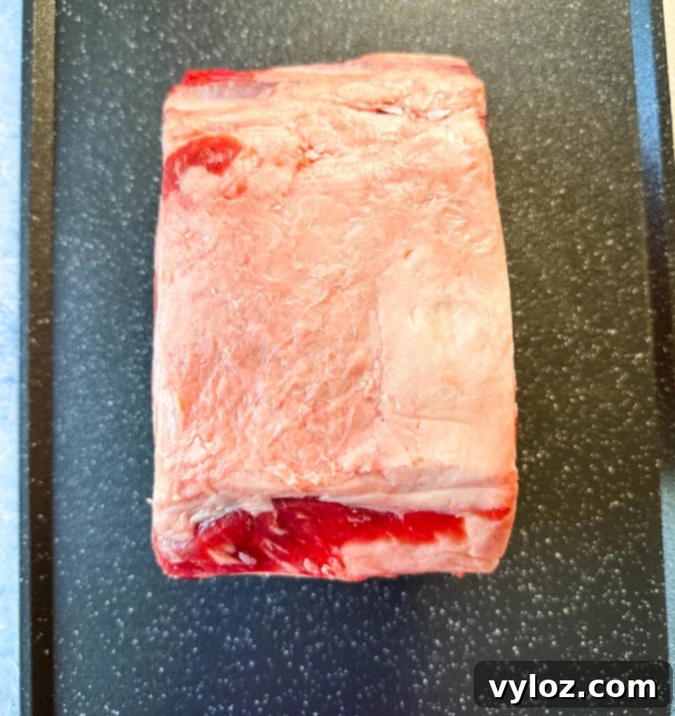 Bone-in or Boneless Garlic Butter Prime Rib 4 raw prime rib roast on a sheet pan