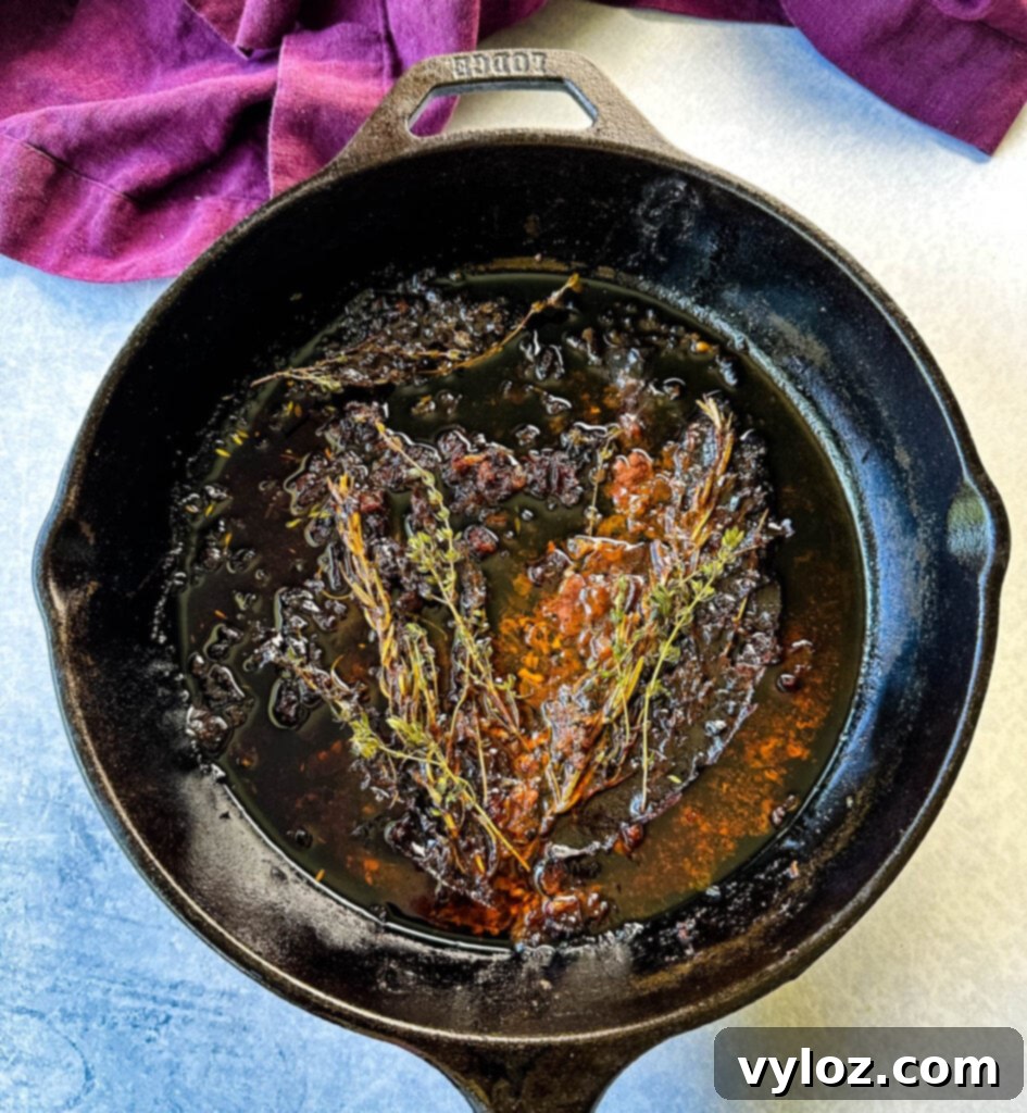 prime rib drippings and herbs in a cast iron skillet