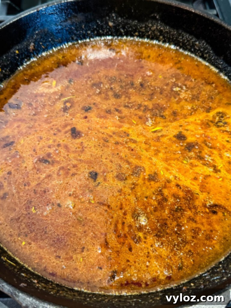 Au Jus gravy sauce in a cast iron skillet