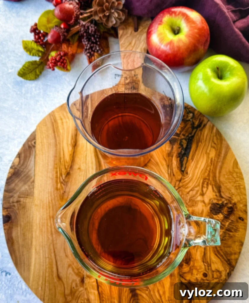Separate glasses of apple cider and bourbon, ready for mixing