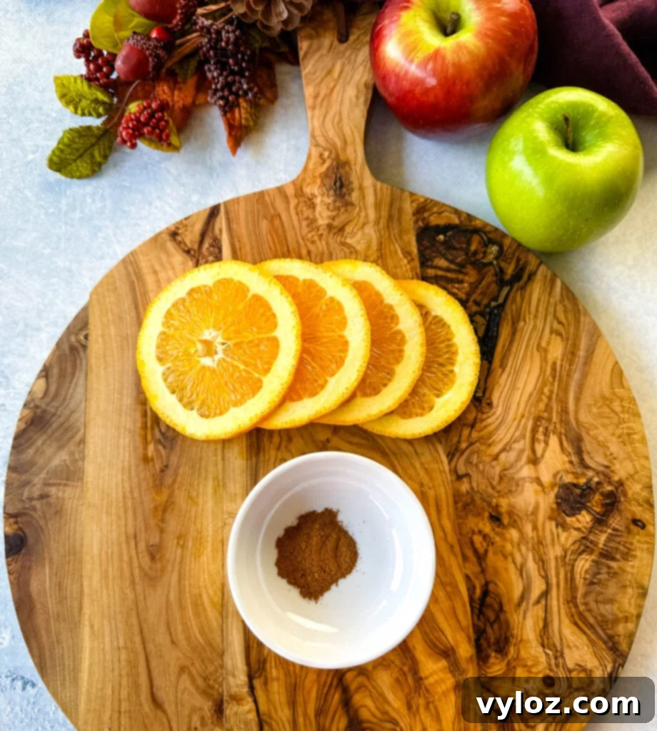 Close-up of fresh orange slices and cinnamon sticks on a wooden surface