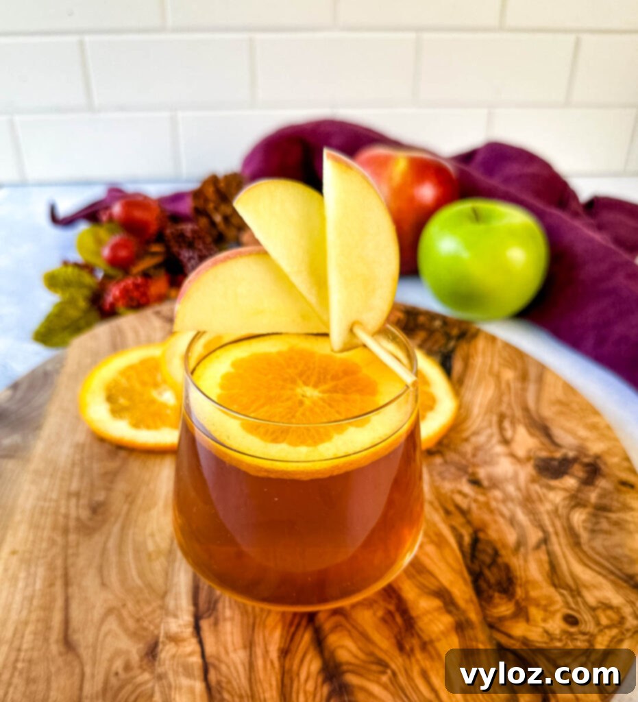 Close-up of apple cider bourbon cocktail with orange and apple slices, a perfect fall drink