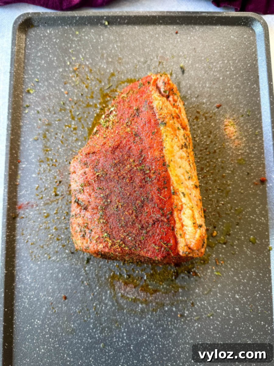 seasoned raw eye of round roast beef on a sheet pan