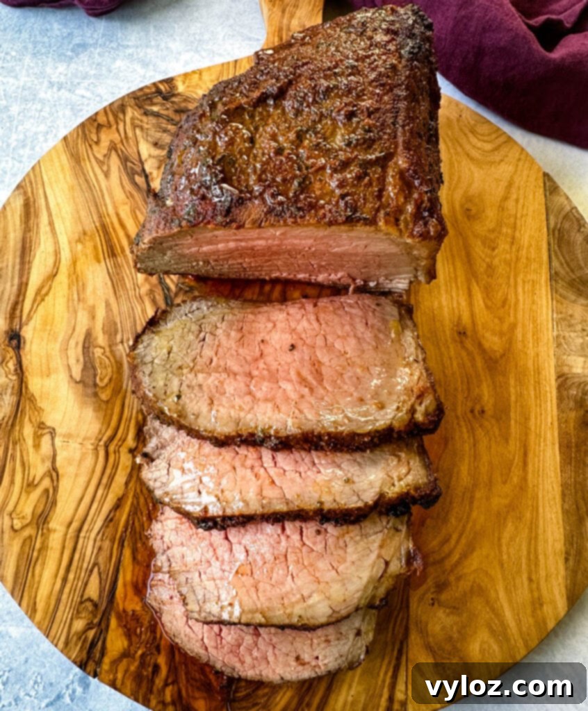 sliced eye of round roast beef on a bamboo board