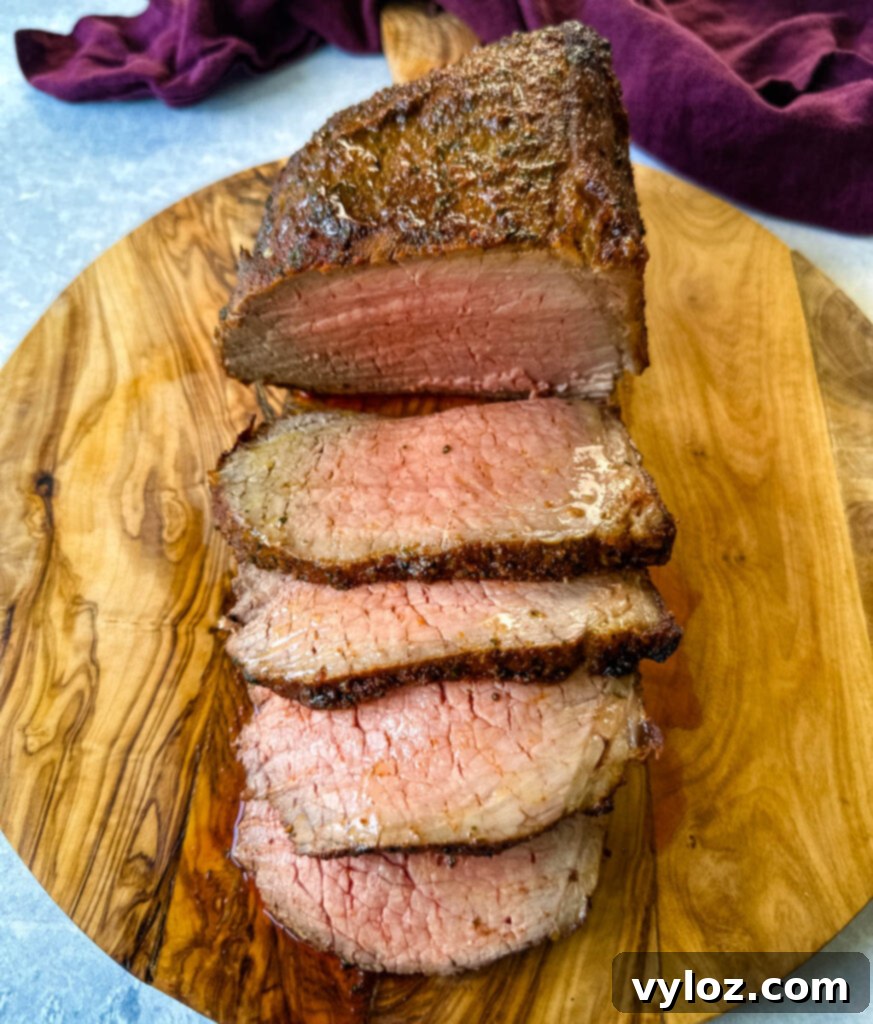 sliced eye of round roast beef on a bamboo board