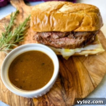 French dip sandwich on a plate with au jus sauce