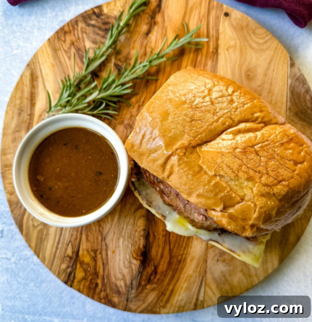 French dip sandwich on a plate with au jus sauce