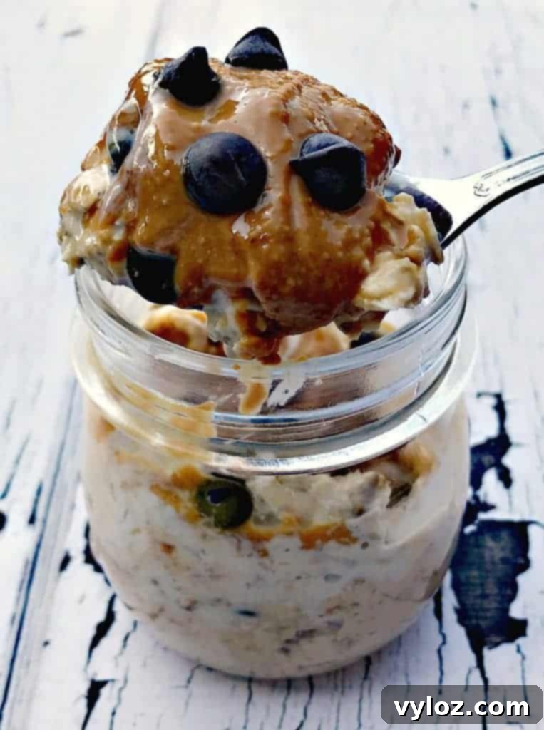 A glass jar filled with luscious Chocolate Chip Cookie Dough Protein Overnight Oats, featuring visible chocolate chips and a creamy texture.
