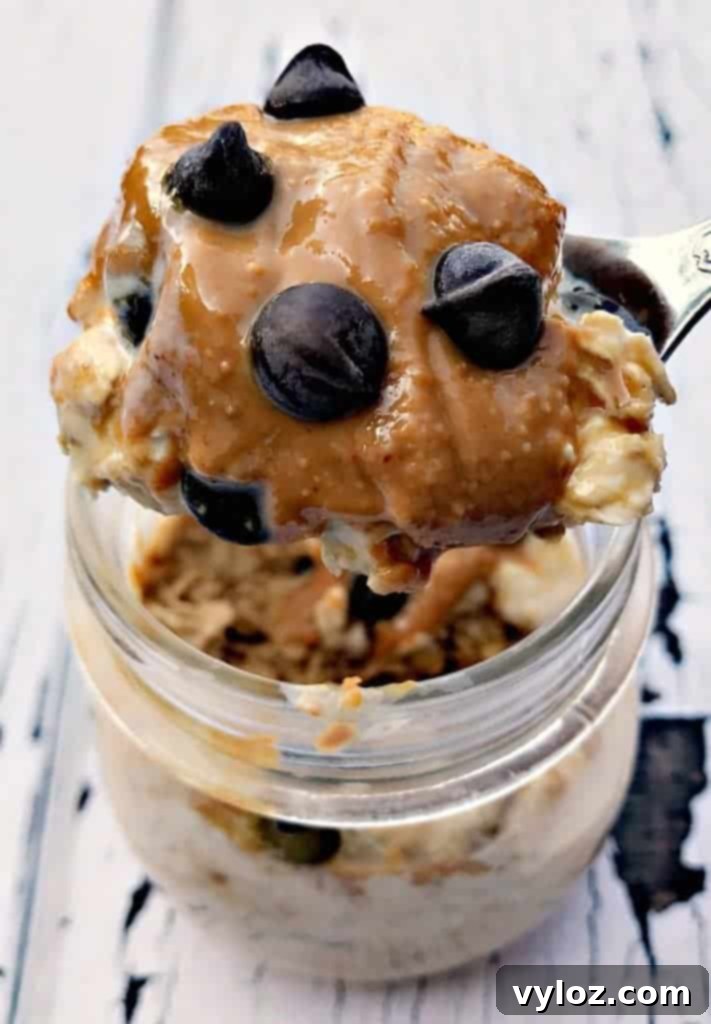 A stack of three glass jars with Chocolate Chip Cookie Dough Protein Overnight Oats, perfectly layered and ready for quick breakfasts.