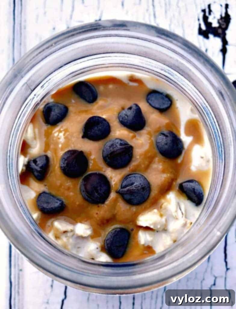 A top-down view of Chocolate Chip Cookie Dough Protein Overnight Oats in a glass jar, showing its creamy texture and chocolate chips.