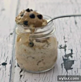 A close-up of a glass jar filled with Chocolate Chip Cookie Dough Protein Overnight Oats.