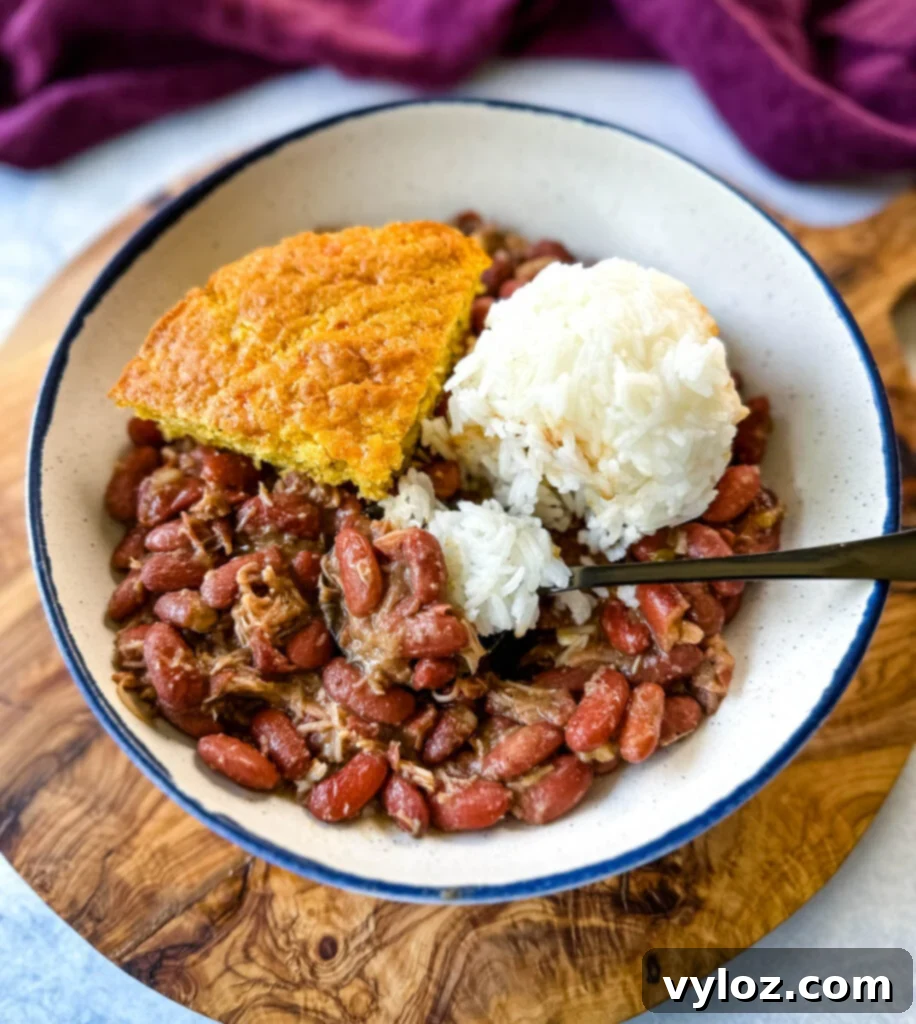 A savory bowl of Southern Cajun red beans and rice, featuring tender smoked turkey, served alongside a slice of golden cornbread, evoking the comforting flavors of New Orleans.