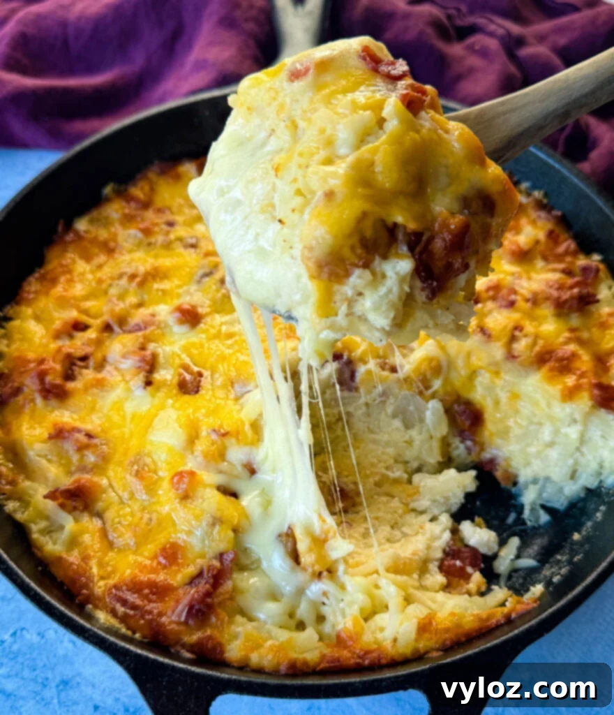 A delicious hash brown breakfast casserole with crispy bacon and melted cheese, served in a cast iron skillet, ready for brunch.