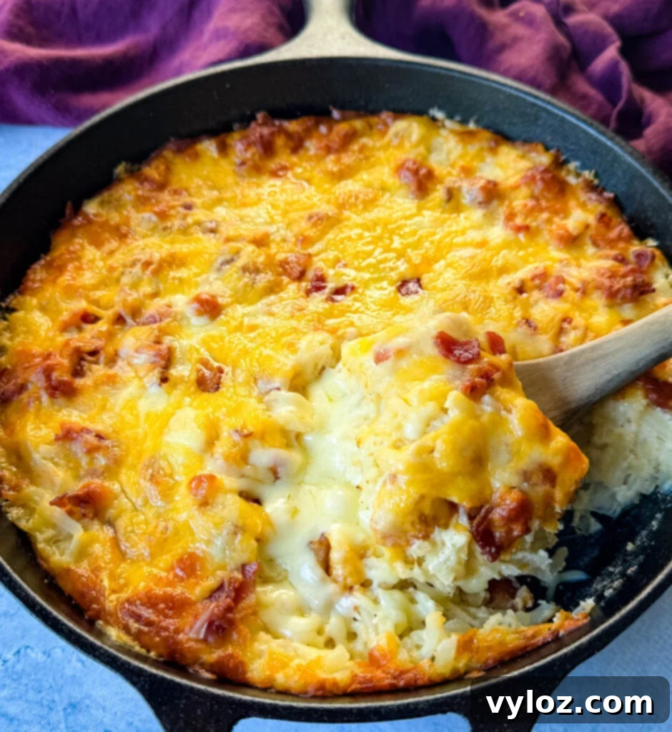 A hearty hash brown casserole with bacon and melted cheese, cooked to golden perfection in a cast iron skillet.