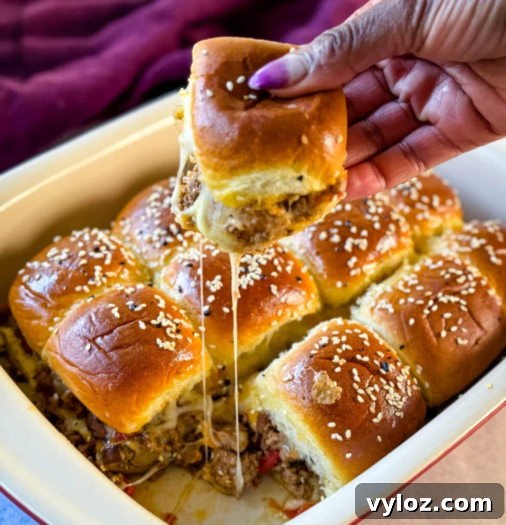 Person holding perfectly crafted Kings Hawaiian Sliders with melted cheese and a golden bun