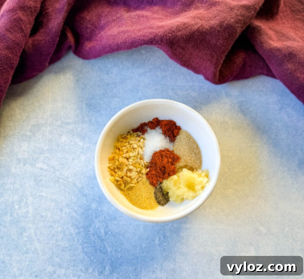 Close-up of a homemade burger rub seasoning blend in a white bowl, showcasing various spices