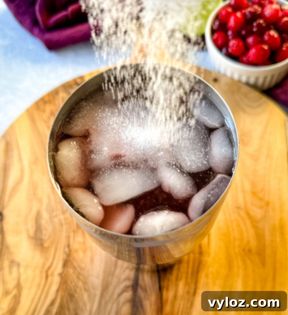 cranberry margarita in a cocktail shaker with sweetener