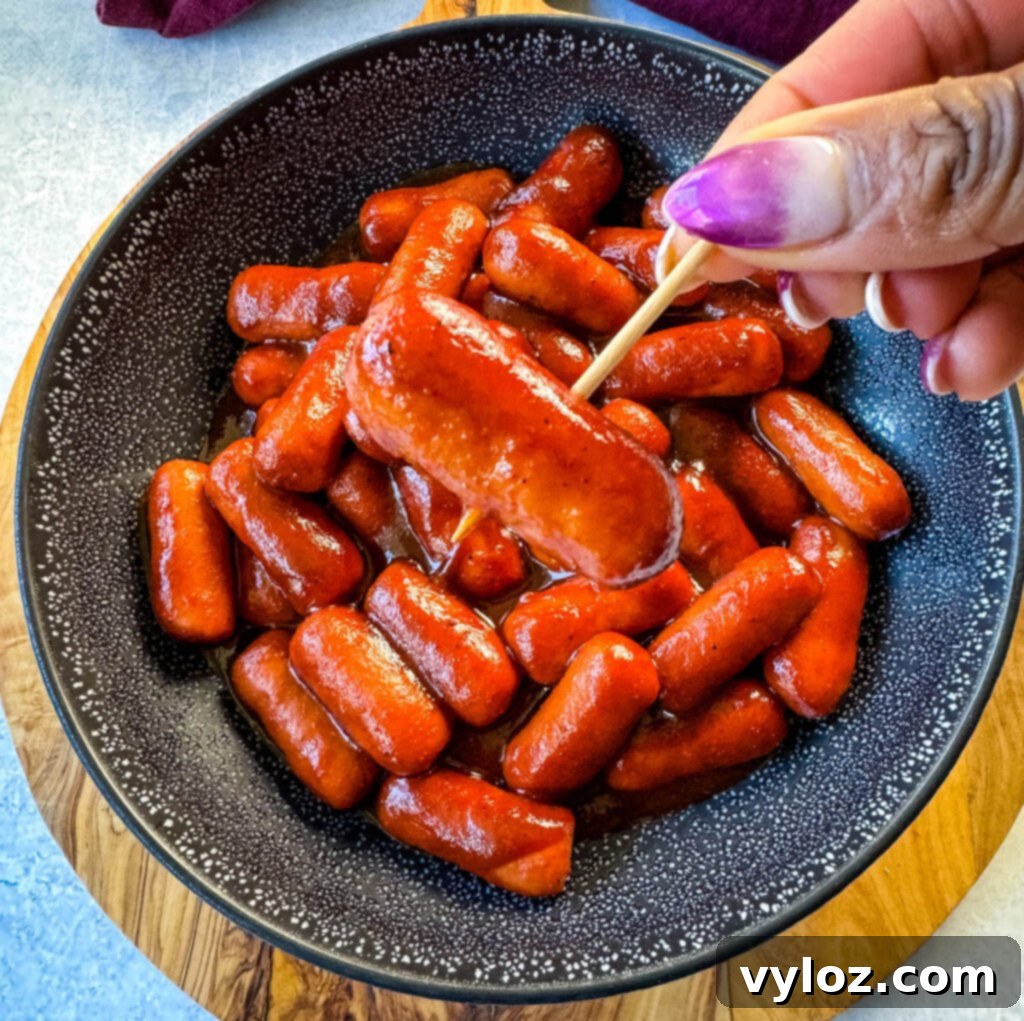 Sweet and Sticky BBQ Little Smokies 11 person holding Little Smokies cocktail sausage