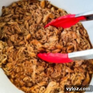 pulled chicken and BBQ sauce in a white Crockpot slow cooker