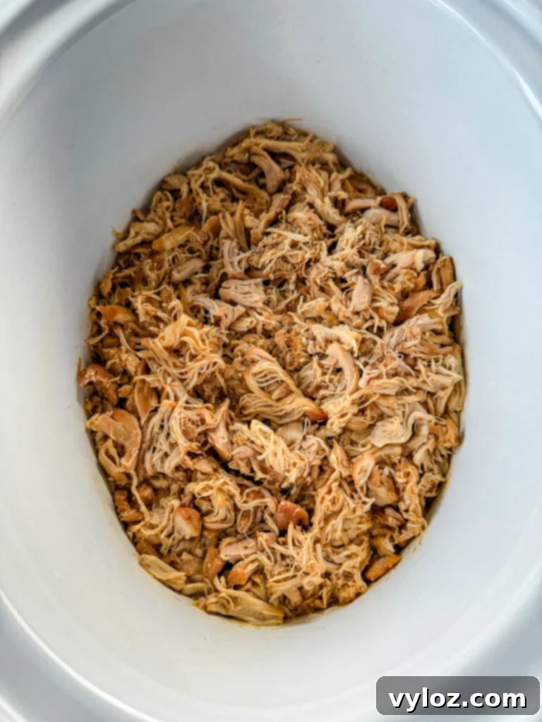 pulled chicken in a white Crockpot slow cooker