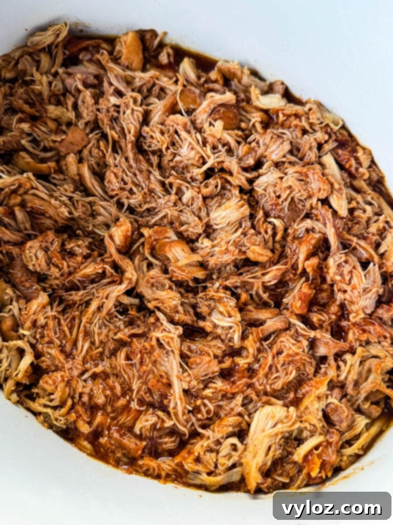 pulled chicken and BBQ sauce in a white Crockpot slow cooker