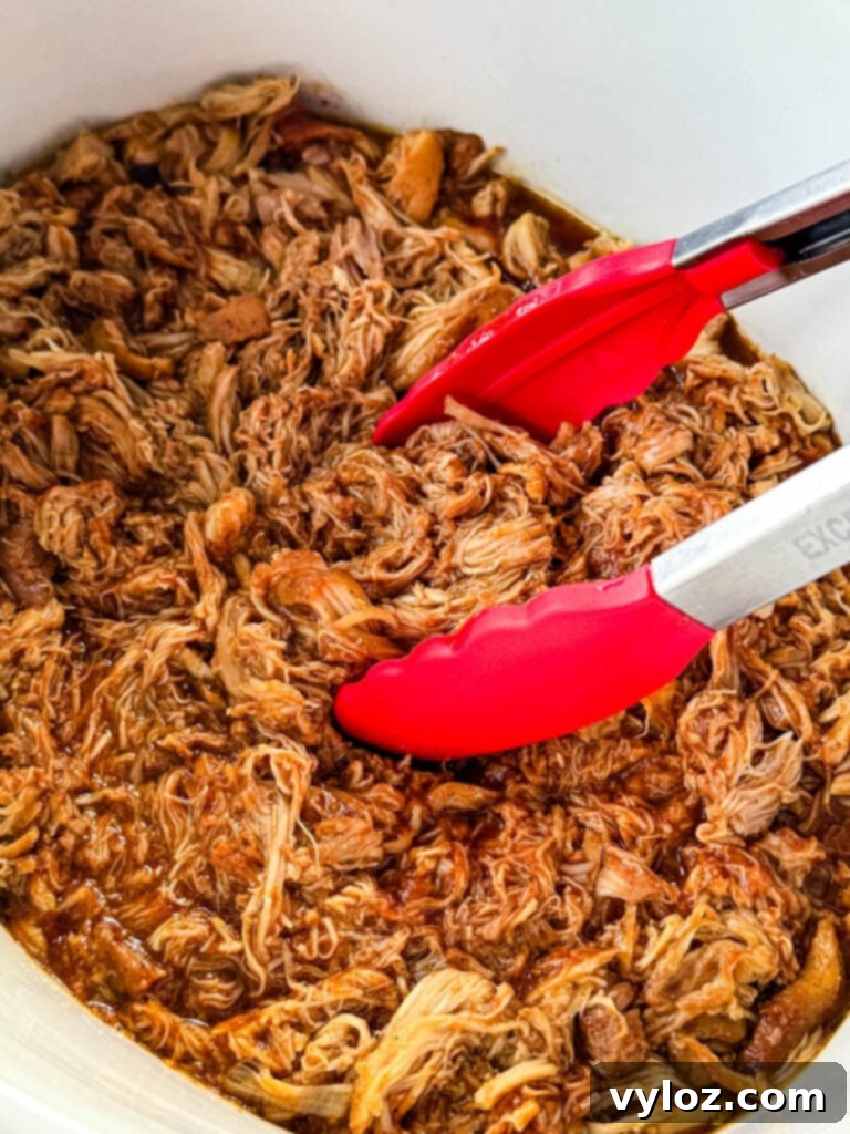 pulled chicken and BBQ sauce in a white Crockpot slow cooker