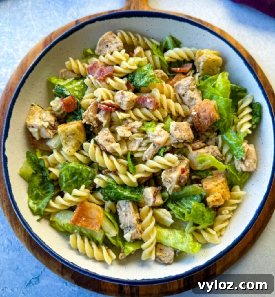 Chicken Caesar Pasta Salad with bacon and croutons in a white bowl