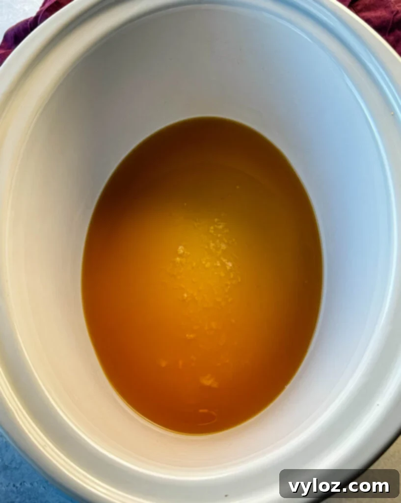 beef broth in a white slow cooker
