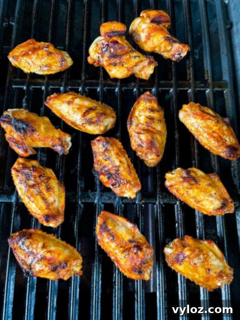 Savory Grilled Chicken Rub 9 Close-up shot of chicken wings sizzling on a hot grill, showing delicious char marks.