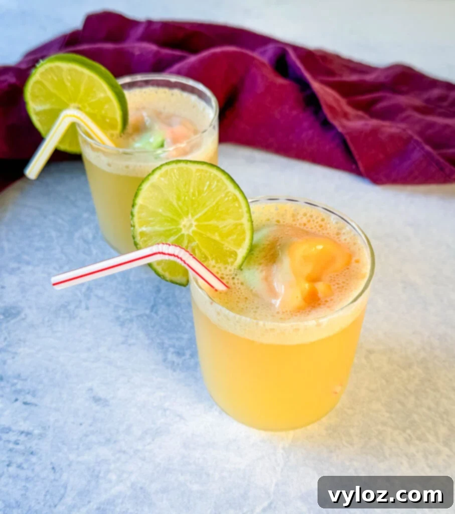 Kaleidoscope Sherbet Punch 2 rainbow sherbet punch in a cup with a lime and straw