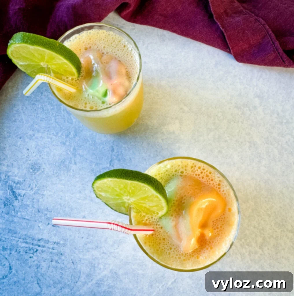 Kaleidoscope Sherbet Punch 7 rainbow sherbet punch in a cup with a lime and straw