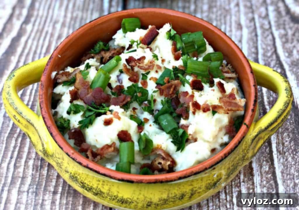 mashed potatoes in a yellow bowl with green onions
