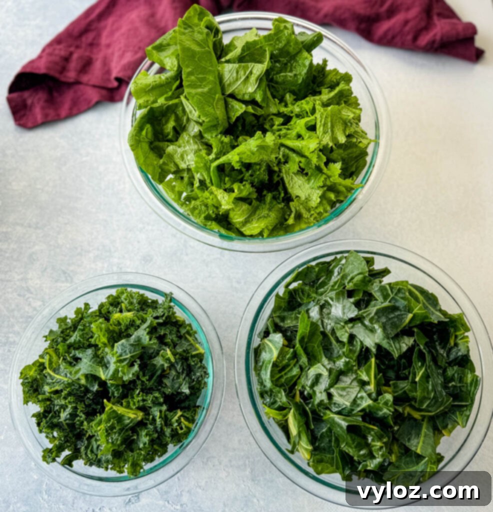 Southern Mixed Greens Medley 3 Fresh collard greens, kale, turnip greens, and mustard greens displayed in separate glass bowls, ready for washing.