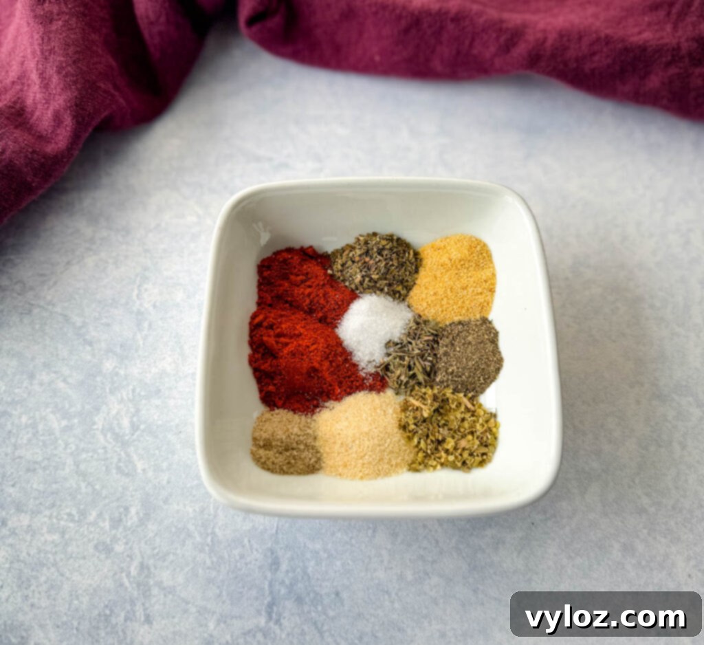 Southern Mixed Greens Medley 5 A small white bowl filled with a homemade Creole seasoning blend, featuring vibrant spices.