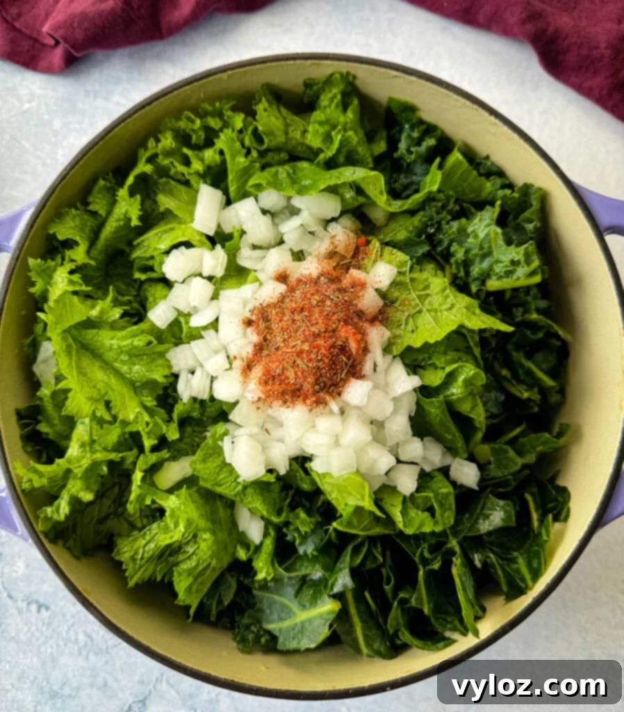 Southern Mixed Greens Medley 6 Uncooked mixed greens, onions, garlic, and Creole seasoning arranged in a Dutch oven, ready for cooking.
