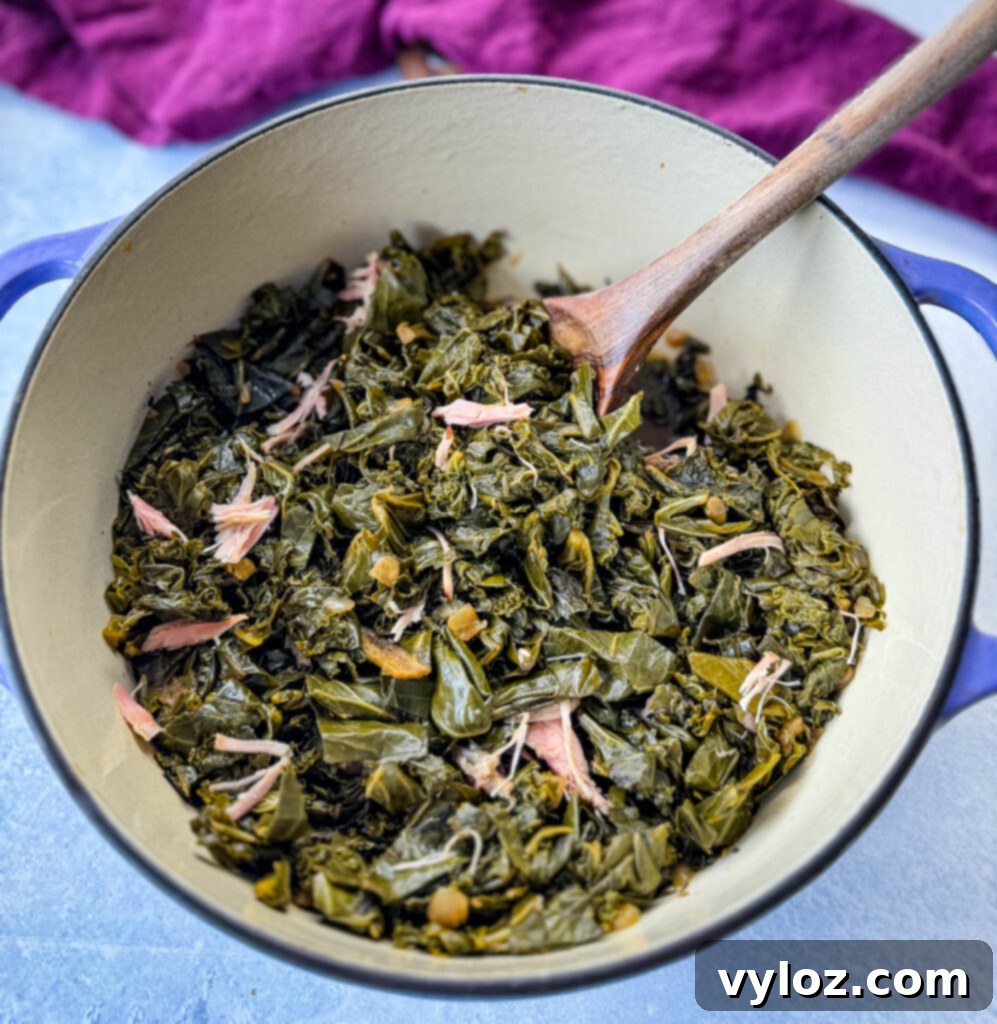 Southern Mixed Greens Medley 9 Tender mixed greens, including collard, turnip, mustard, and kale, in a Dutch oven with a wooden spoon, ready to serve.