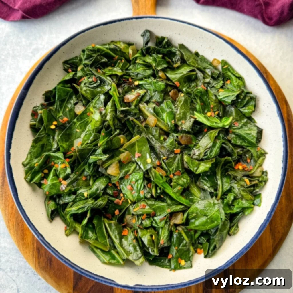 Sautéed collard greens with crushed red pepper in a white bowl, ready to serve.