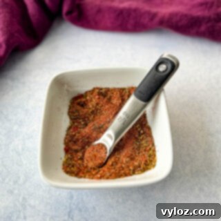 collard greens seasoning dry spices in a white bowl with a measuring spoon