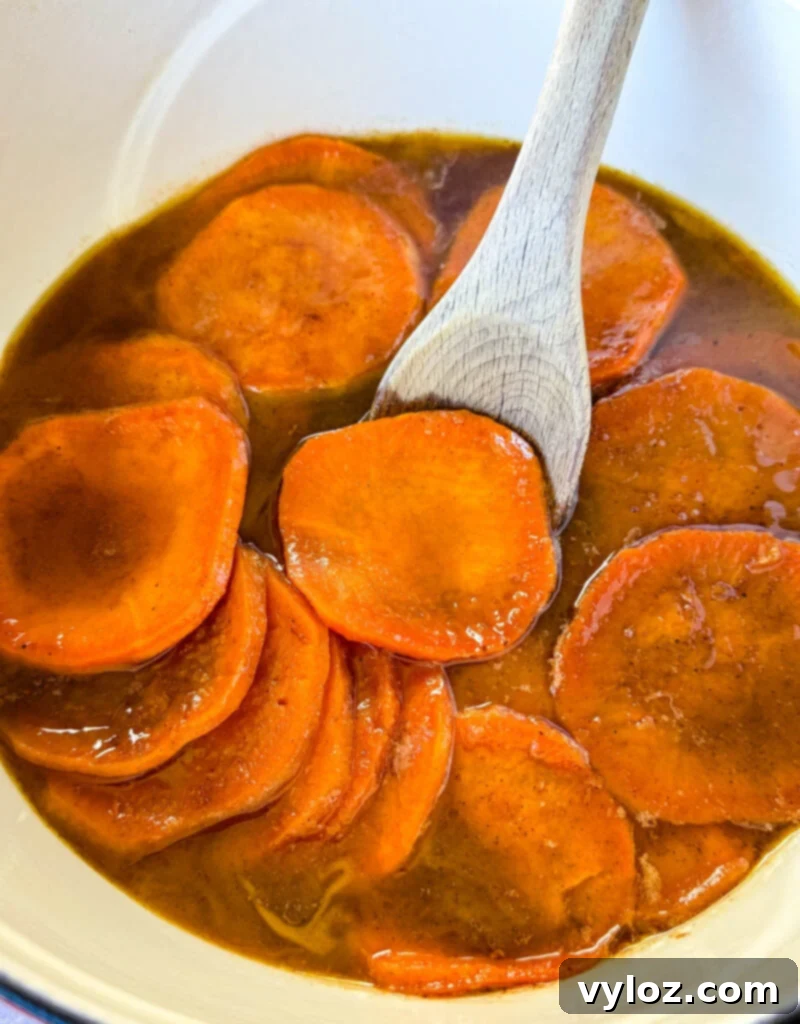 Stovetop Glazed Sweet Potatoes 2 stovetop Southern soul food candied sweet potatoes yams in a Dutch oven with a wooden spoon