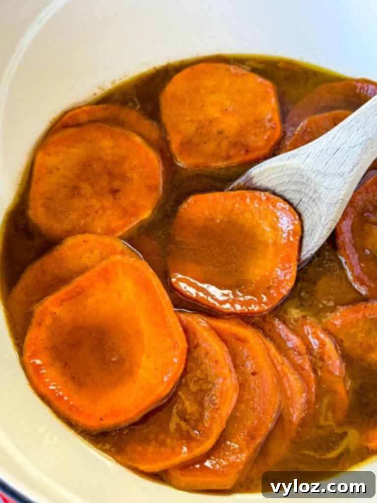 Stovetop Glazed Sweet Potatoes 11 stovetop Southern soul food candied sweet potatoes yams in a Dutch oven with a wooden spoon