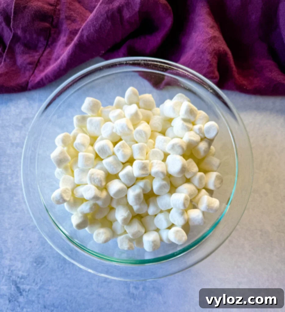 A bowl filled with fluffy white marshmallows, ready to be sprinkled over candied sweet potatoes.