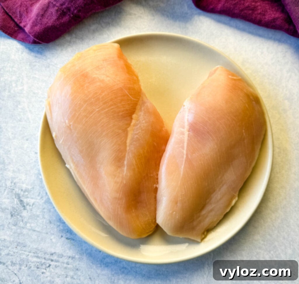 2 raw chicken breasts on a plate