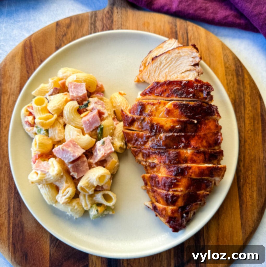 baked bbq chicken breast with pasta salad on a platte