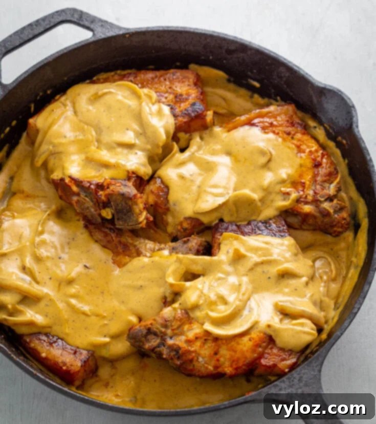 Southern Smothered Pork Chops, fried with onions and drizzled in thick gravy